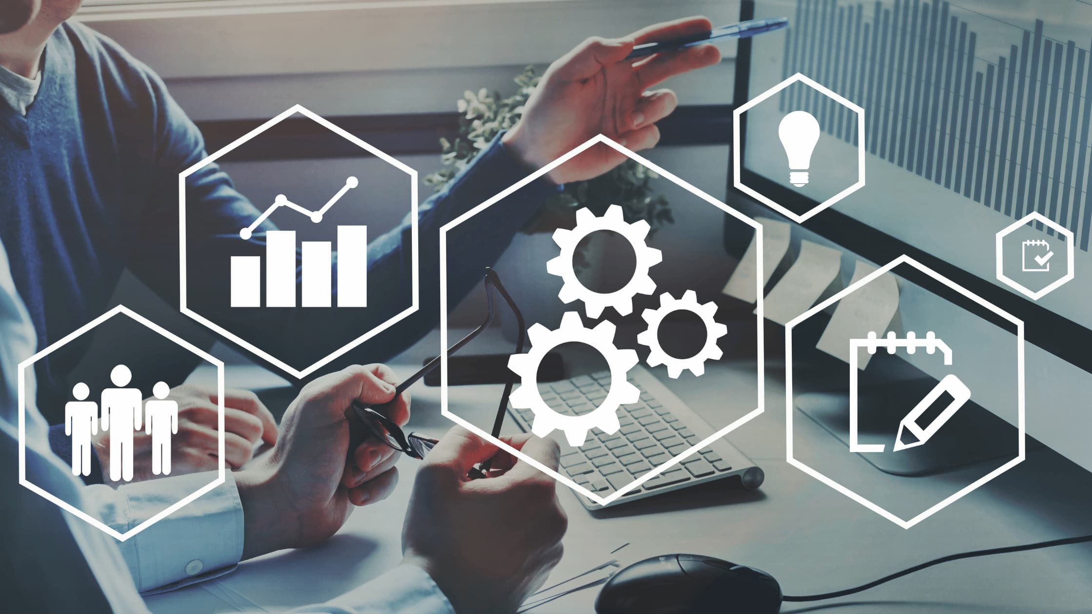 Business team analyzing data on a desktop computer with overlay icons for growth, teamwork, and innovation